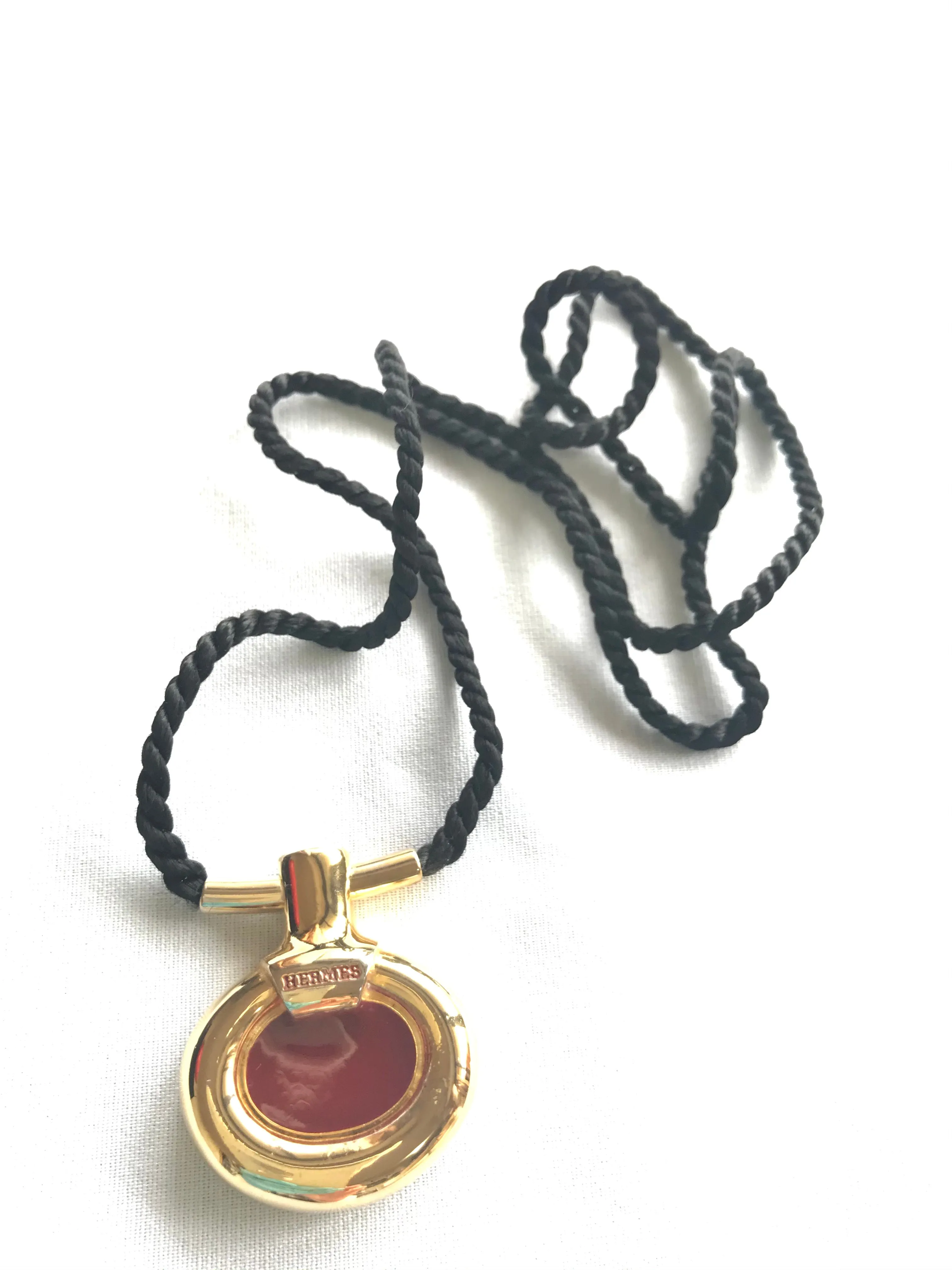 Vintage Hermes golden and red stone charm pendant top necklace with black strings. Unique jewel piece from PARFUM Collection. 060919re1