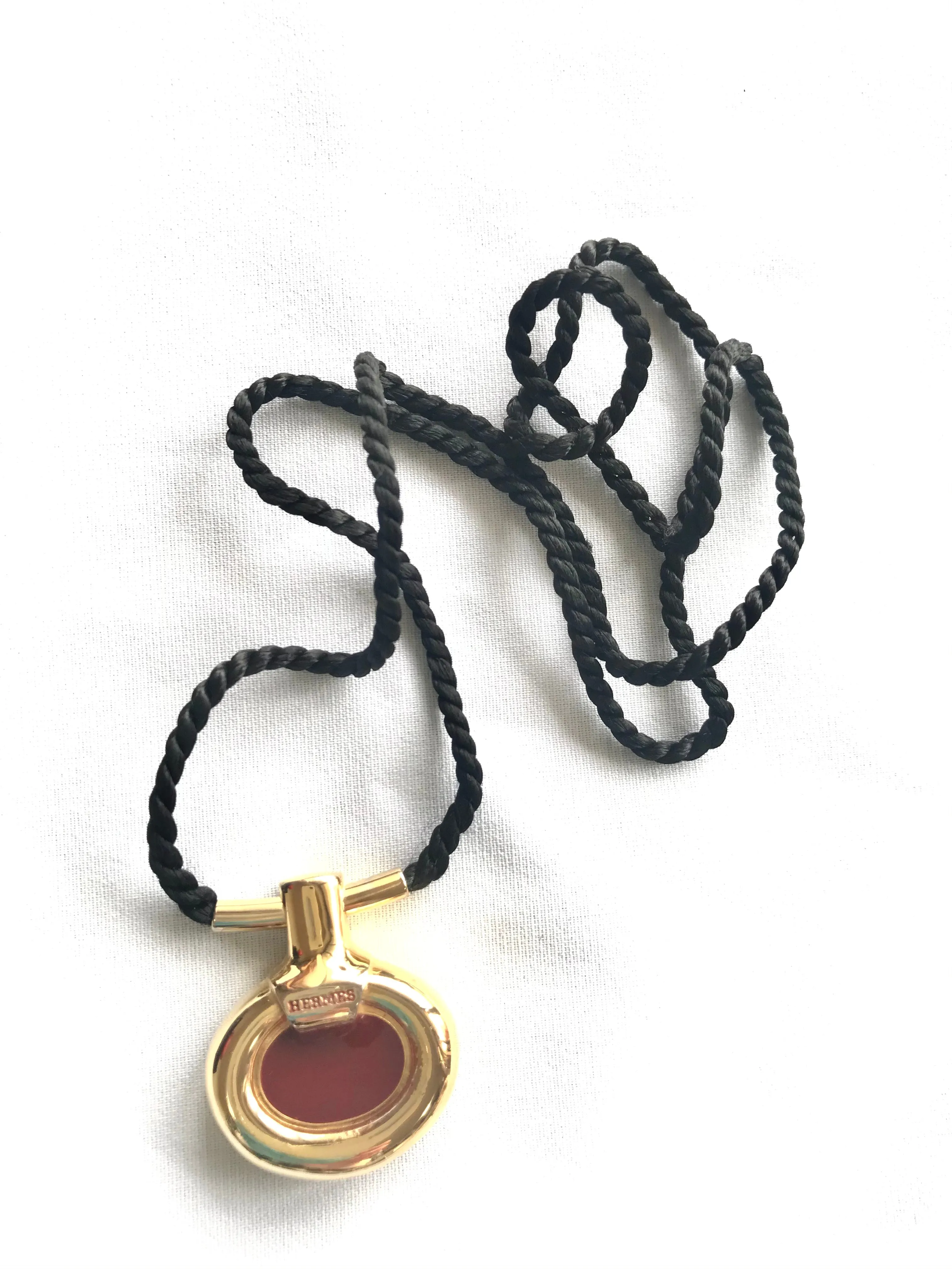 Vintage Hermes golden and red stone charm pendant top necklace with black strings. Unique jewel piece from PARFUM Collection. 060919re1